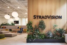 an office lobby with plants and couches in front of the sign that says stradvision