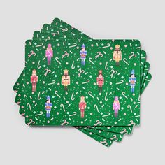 three green paper napkins with cartoon characters on them and candy canes all over them