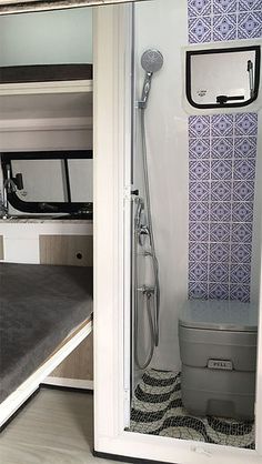 the inside of a camper with its door open and a bed in front of it