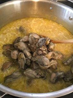 clams are being cooked in a pot on the stove