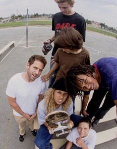 a group of people standing around each other with skateboards