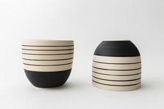 two black and white vases sitting next to each other