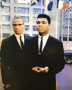 two men in suits standing next to each other