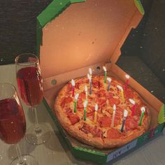 a pizza in a box with candles on it