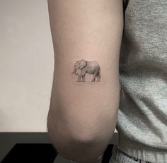 an elephant tattoo on the left arm is shown in black and white, while it's smaller than the rest of the arm