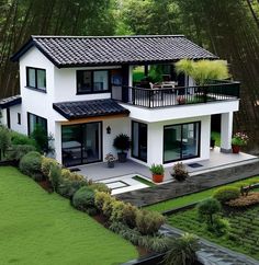 an aerial view of a white house in the middle of some trees and grass area