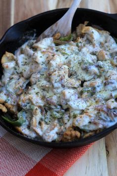 a skillet filled with food on top of a wooden table