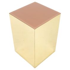 a gold cube with a pink top on a white background