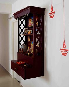 a book shelf is hanging on the wall next to a cabinet with many items in it