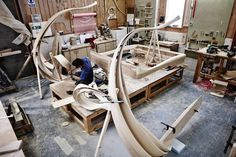 a man working on a wooden boat in a shop