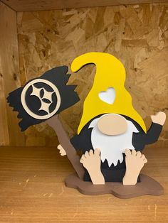 a paper cut out of an old wizard with a yellow hat and two black bats