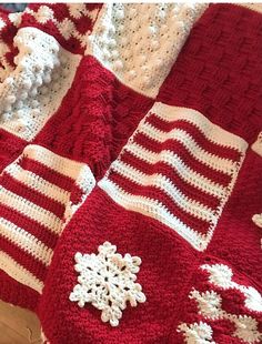 a crocheted blanket with snowflakes on it is laying on the floor