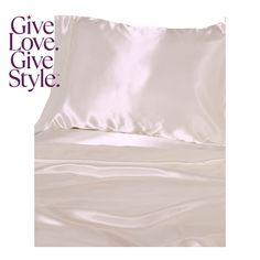 a bed with white sheets and purple lettering on the pillowcase that says give love, give style