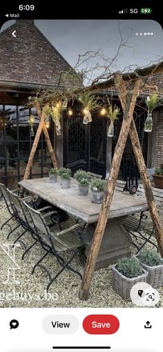 an image of a table and chairs with plants on them in front of a building