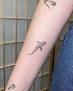 a small shark tattoo on the arm