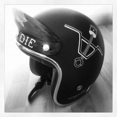 a black helmet with white writing on it sitting on a wooden floor next to a wall