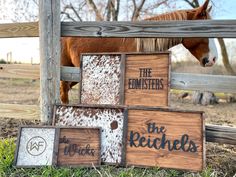 there is a horse that is standing next to the fence and some signs in front of it