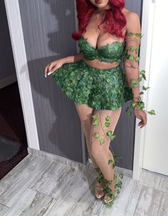 a woman with red hair wearing a green costume