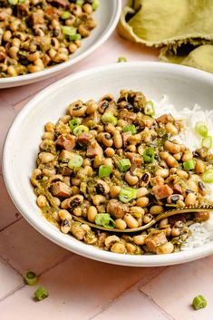 two bowls filled with beans and rice on top of a pink countertop next to green vegetables