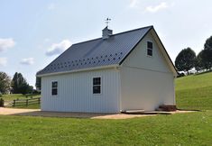 a small white barn with a steeple on top