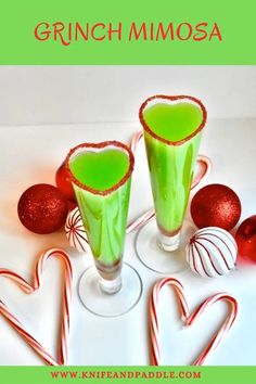 two glasses filled with green liquid next to candy canes