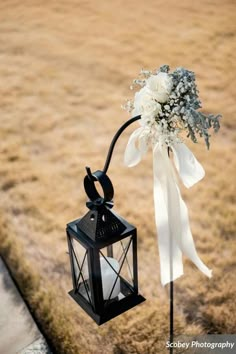 a black lantern with white flowers tied to it