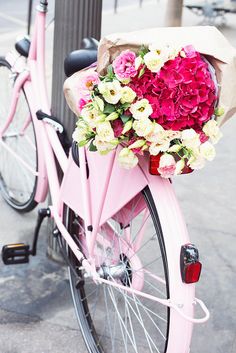 a pink bicycle with flowers on the back