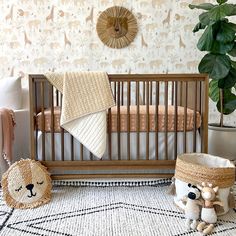 a baby crib with two stuffed animals next to it and a potted plant