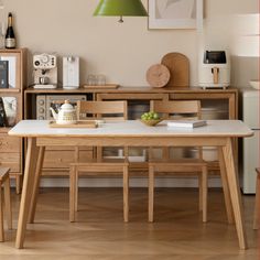 a wooden table sitting in front of a white refrigerator