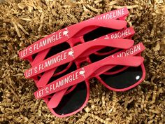 five pairs of red sunglasses sitting on top of wood shavings with the words let's flamingglile and let's flaminggly written on them