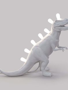 an image of a white dinosaur with lights on it's head and tail, standing in front of a gray background