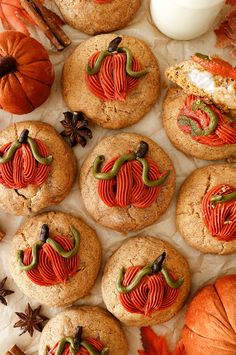 cookies decorated with pumpkins and leaves on top of parchment paper