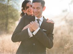 a man and woman hugging each other outside