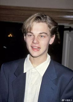 a young man wearing a suit and white shirt