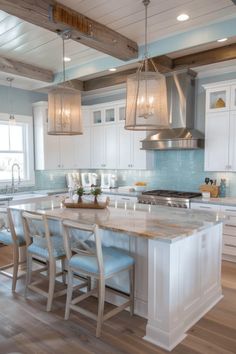 a large kitchen with white cabinets and wooden floors