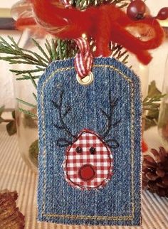 a christmas ornament hanging from a tree in front of a glass jar filled with pine cones