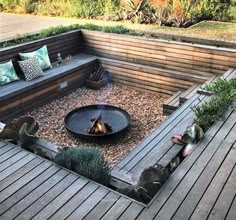 an outdoor fire pit surrounded by wooden decking