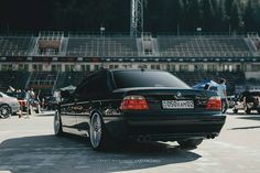 a black car parked in front of a stadium