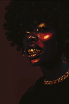 a woman with dark skin and gold jewelry