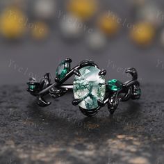 a ring with green stones and leaves on it