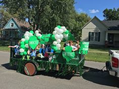 some people are riding in the back of a truck with balloons and streamers on it