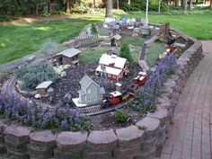 a model train set is in the middle of a garden