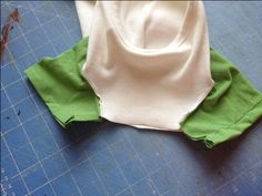 two green and white shirts sitting on top of a cutting board