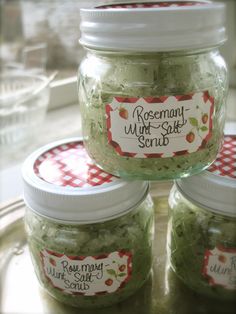 three jars filled with green food sitting on top of a metal table next to each other