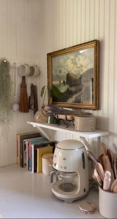 a kitchen counter with utensils and a painting on the wall in the background