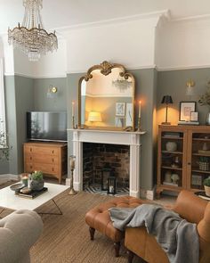 a living room filled with furniture and a large mirror on the wall above a fire place