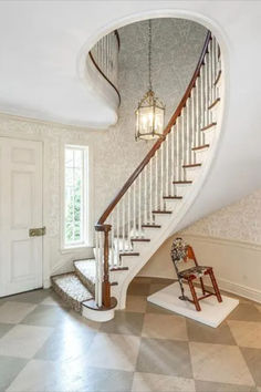 a staircase leading up to the second floor in a house with white walls and checkered floors