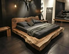 a large bed sitting on top of a hard wood floor next to a wall mounted deer head