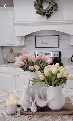 a vase filled with flowers sitting on top of a kitchen counter next to a candle