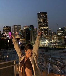 a woman taking a selfie with her cell phone in the city at night time